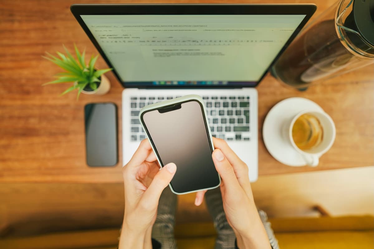Person using multiple devices at once, representing scattered attention