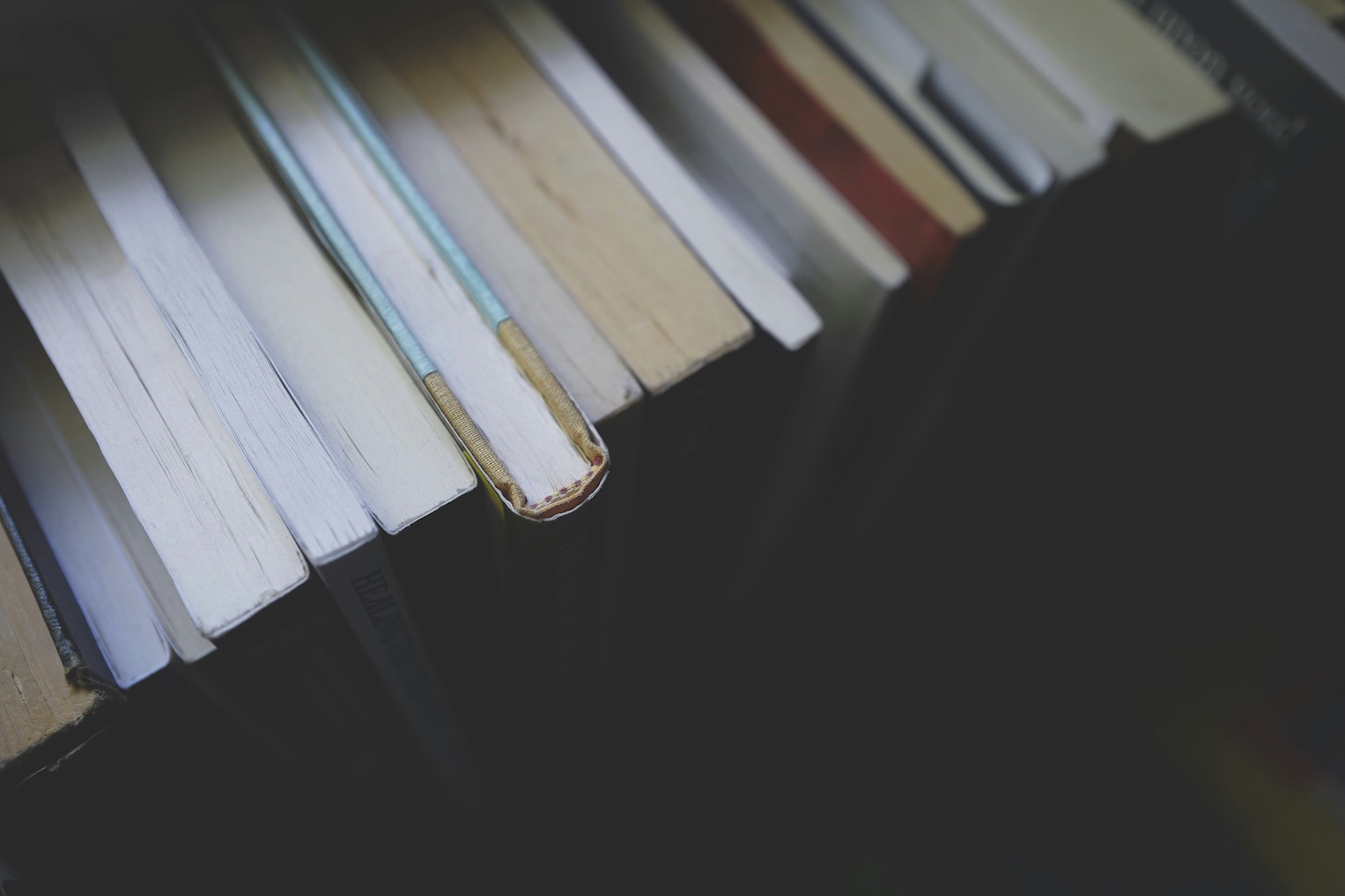 Stack of finished books on a windowsill, evening light, no rush